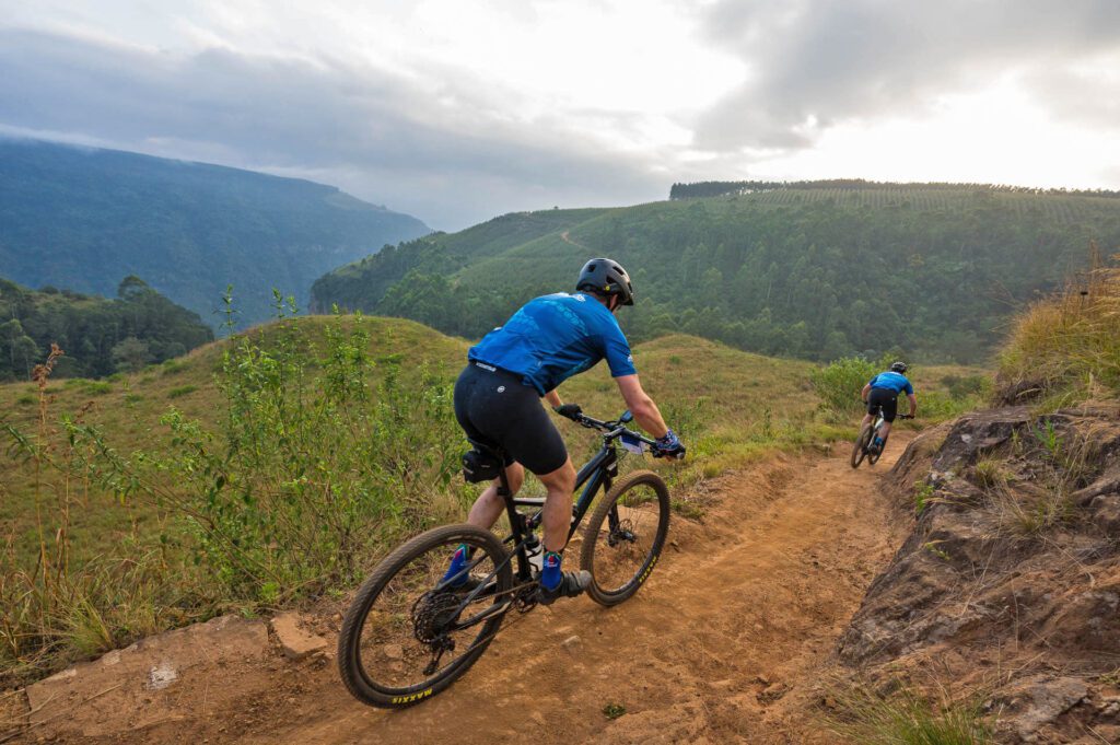 Sani2C,Even after 21 years, Farmer Glen and his team are constantly refining the experience. “We’re always tweaking the route. It might be small things, but they make a big difference,” he explains. This year, there’s a new farm section on Day One, while Day Three will see a fresh attempt at making the famous Scottburgh lagoon crossing more dramatic.